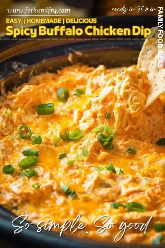 creamy spicy buffalo chicken dip topped with melted cheese and green onions served in a slow cooker