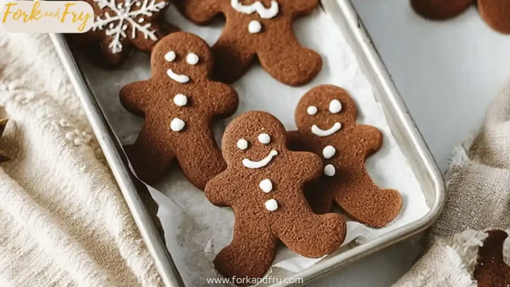 chocolate gingerbread cookies shaped like gingerbread men on a parchment-lined tray