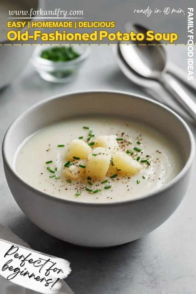 Classic potato soup in a grey bowl topped with diced potatoes, chives, and black pepper