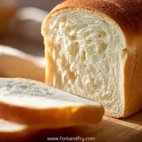 sliced soft white bread loaf with fluffy texture on wooden board